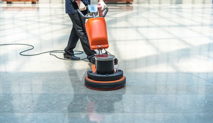 Person cleaning floor in a commercial space Person cleaning floor in a commercial space
