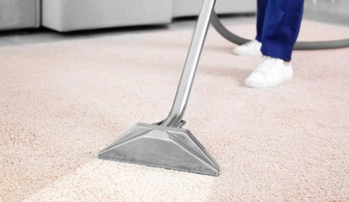 Worker cleaning carpet with equipments