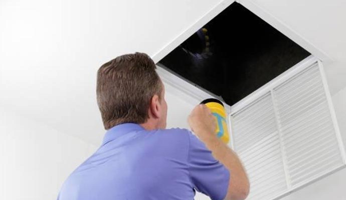 Professional expert inspecting air duct